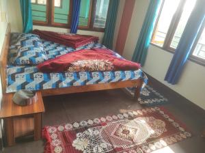 a bedroom with a bed and a rug and windows at Laxmi Homestay in Kalimpong