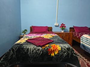 a bedroom with a bed with purple sheets and red pillows at Laxmi Homestay in Kalimpong