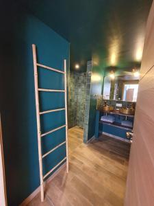 a bathroom with a blue wall with a ladder in it at Surf & Sauna Bud House in Longeville-sur-Mer