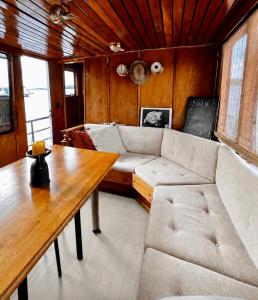 a living room with a couch and a table at Saimaa Experience - laivamajoitus in Puumala