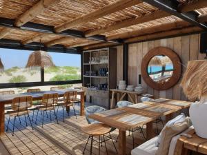 a dining room with a table and chairs and a mirror at Luxury Villa with Private Pool e Jacuzzi Year-Round a 25 min de Lisboa in Setúbal
