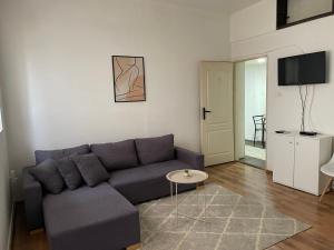 a living room with a blue couch and a table at Fenix Apartman II in Zaječar