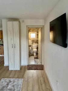 a bathroom with a toilet and a television on a wall at JazAzur in Lastva +17 photos
