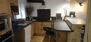 a kitchen with a black counter and a black chair at Charmante et Chaleureuse petite maison in Châteauneuf-du-Pape +13 photos