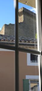 a view of a castle through a window at Charmante et Chaleureuse petite maison in Châteauneuf-du-Pape