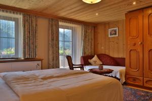 a bedroom with a bed and a chair and window at Pension Monteneu in Bartholomäberg +40 photos