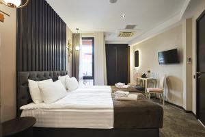 a hotel room with a large bed with white sheets at Panorama Boutique Hotel in Tbilisi City