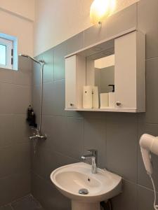 a bathroom with a sink and a mirror at Yamas Hotel "Ex Malibu" in Dhërmi +76 photos