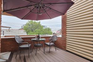 a patio with a table and chairs and an umbrella at Panorama Boutique Hotel in Tbilisi City