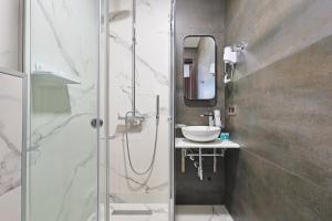 a bathroom with a glass shower and a sink at Panorama Boutique Hotel in Tbilisi City +34 photos