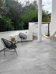 two chairs and a hammock on a patio at casa de mineiro in Tiradentes