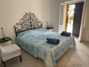 a bedroom with a bed with two blue towels on it at Nonna Antonietta in San Teodoro