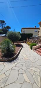 a stone walkway with some plants and a house at chez Henri-Ange in Saint-Raphaël