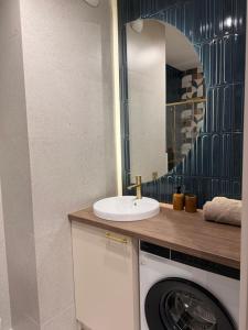 a bathroom with a sink and a washing machine at COSMO Premium Park Chorzów, Parking, f-VAT klimatyzacja in Chorzów +4 photos