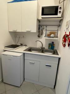 a small kitchen with a sink and a microwave at Nonna Antonietta in San Teodoro +26 photos