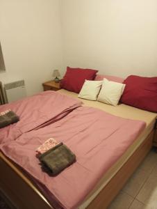 a bed with two red and white pillows on it at Chalet Sedmihori in Staré Sedlo