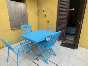 a blue table and chairs sitting next to a house at Nonna Antonietta in San Teodoro