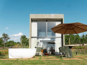 a bath tub and an umbrella in front of a house at Loft Alegria in Avaré