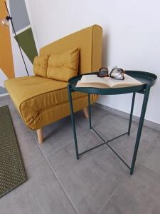a table and a couch with glasses and a book at Casa RAFFAELLO in Vigevano