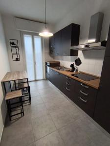a kitchen with black cabinets and a table and chairs at Casa RAFFAELLO in Vigevano