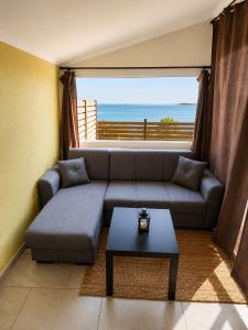 a living room with a couch and a large window at Ouranoupolis View Point in Ouranoupoli