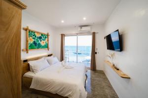 a hotel room with a bed and a window at Antuwanga reef resort in Moalboal