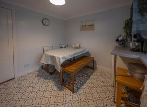 a room with a table and a sink and a clock at Shop Cottage, Findhorn in Findhorn