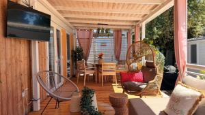 a screened in porch with a television and a table and chairs at Iris Holiday Homes in Biograd na Moru