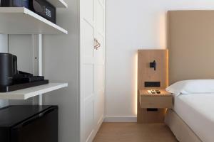 a small bedroom with a bed and a night stand with a television at Hotel Don Ignacio in San José