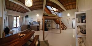 a large living room with a bench and a kitchen at Valhalla Mentawai in Katiet