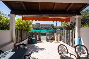 a patio with a table and chairs and a fence at Trilocale - Via Pisa in San Teodoro