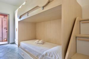 a bedroom with a bunk bed with white sheets at Trilocale - Via Pisa in San Teodoro +10 photos