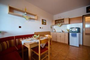 a kitchen and dining room with a table and a refrigerator at Apartmány Dřevařská Benecko in Benecko
