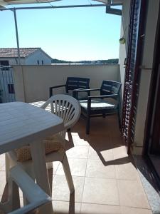 a balcony with chairs and a table and an umbrella at LadyBird and Turtle in Podglavica