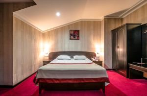 um quarto com uma cama grande e um tapete vermelho em Kopala Tskneti Hotel em Tsqnetʼi