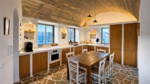 a kitchen with a wooden table and chairs at Kohili Private Villa in Karistos