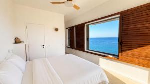 a bedroom with a white bed and a large window at Kohili Private Villa in Karistos