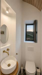 a bathroom with a sink and a toilet and a window at Kohili Private Villa in Karistos +48 photos