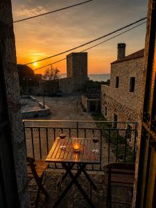 a table on a balcony with a sunset in the background at Diaks Tower Sunset Sea View Mani in Pyrgos Dirou +27 photos