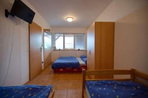 a small room with two beds and a tv at Apartmány Dřevařská Benecko in Benecko