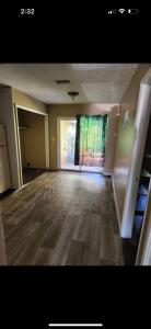 an empty room with a large window and a room with wooden floors at Pixie hollow single vacation retreat resort dwelling in Orlando