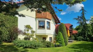 a house with a green yard with bushes at Ferienwohnung Sonnenblick in Bischofswerda
