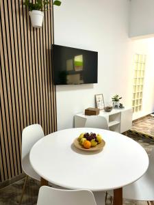 a white table and chairs with a plate of fruit on it at Casa Agustina in Arguineguín