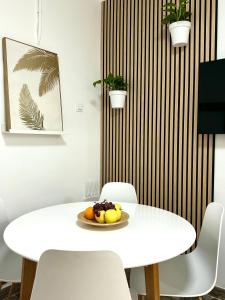a white table and chairs with a plate of fruit on it at Casa Agustina in Arguineguín
