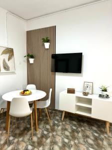 a living room with a table and chairs and a tv at Casa Agustina in Arguineguín