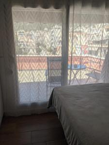 a bedroom with a bed and a large window at Aquamarine Centrale in Kavála