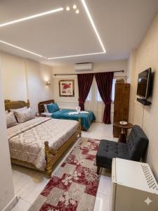 a bedroom with a bed and a couch and a tv at Le caire Hotel & suits in Cairo