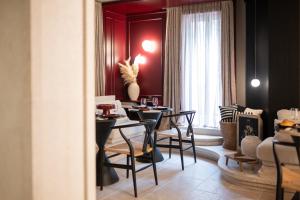a dining room with tables and chairs and a red wall at La Villa Residence in Rovinj