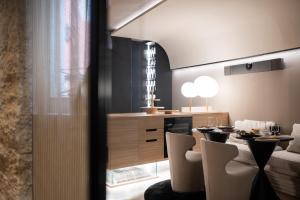 a dining room with a table and chairs and a kitchen at La Villa Residence in Rovinj