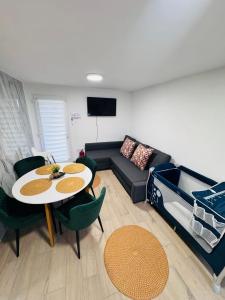 a living room with a couch and a table and chairs at Fresh Time Apartment in Kecskemét